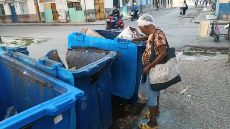 Una cubana hurga en la basura en una calle de La Habana.